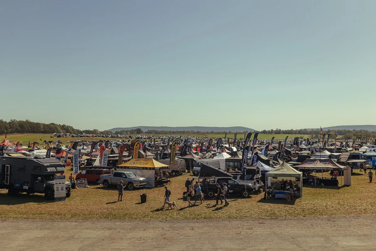 Field full of exhibitors and adventure vans from Overland Expo East 2024 near Arrington, Virginia.